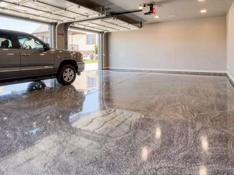 Large garage with a glossy grey marbled metallic epoxy floor reflecting the ceiling lights